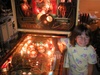 Alyssa posing next to the pinball game (restoration in progress) called Eight Ball Deluxe