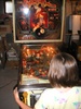 Alyssa playing the pinball game from top front.