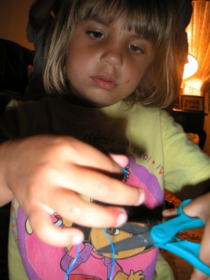 Emily cutting the string for the necklace.